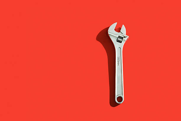 Silver Wrench Wrench with shadow over a red background adjustable wrench photos stock pictures, royalty-free photos & images