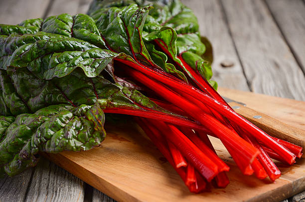 istock Fresh red chard leaves on wooden background 579418980