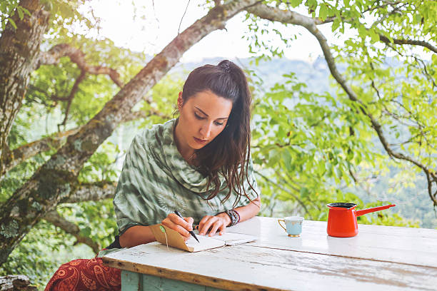 istock Young woman writing in the beautiful nature 579419064