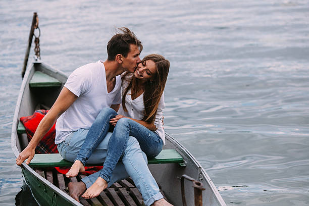 Young couple is standing on a footbridge and enjoys the view over the lake, winter time