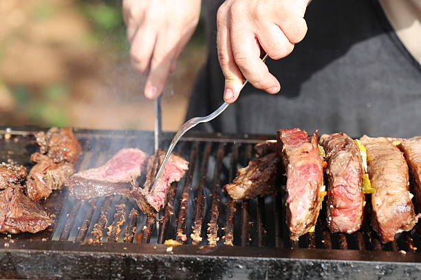 mani che tagliano la carne con strumenti griglia - bon appetite foto e immagini stock