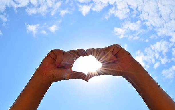 istock heart shape with hands love concept sky background 579427372