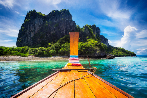 Traditional long tail boat on the way to famous Maya Bay beach in Koh Phi Phi Island, Krabi, Southern Thailand.