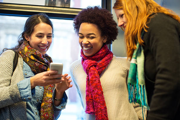 istock Friends traveling by train using mobile phone 579429138