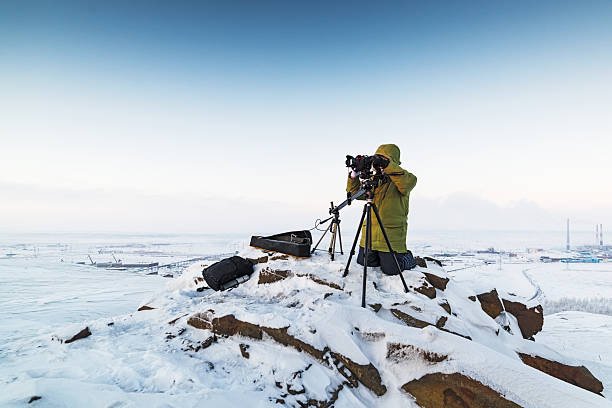 uomo con fotocamera su treppiede che scatta foto timelapse in - sunrise mountain winter arctic foto e immagini stock