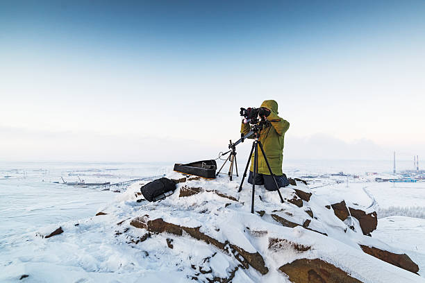 homem com câmera fotográfica no tripé tirando fotos de timelapse em - sunrise mountain winter arctic - fotografias e filmes do acervo
