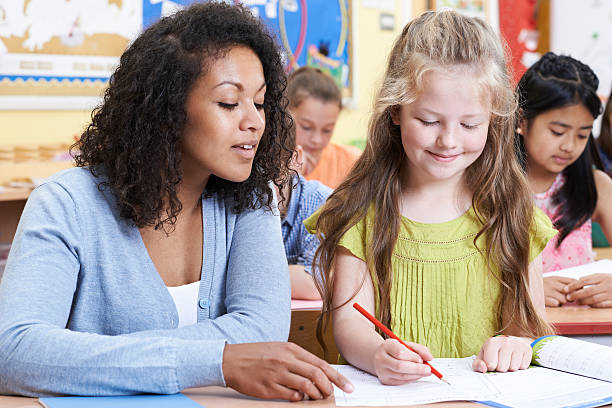istock Teacher With Female Elementary School Pupil In Class 579430208