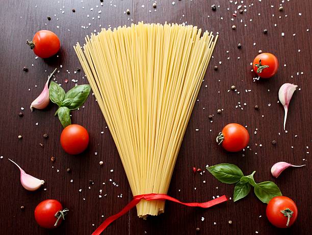 Ingredients for cooking pasta with tomato, black pasta, herbs, spices.