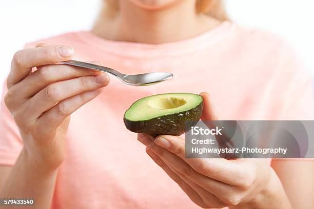 Close Up Of Woman Eating Avocado With Spoon Stock Photo - Download Image Now - Avocado, Eating, Women