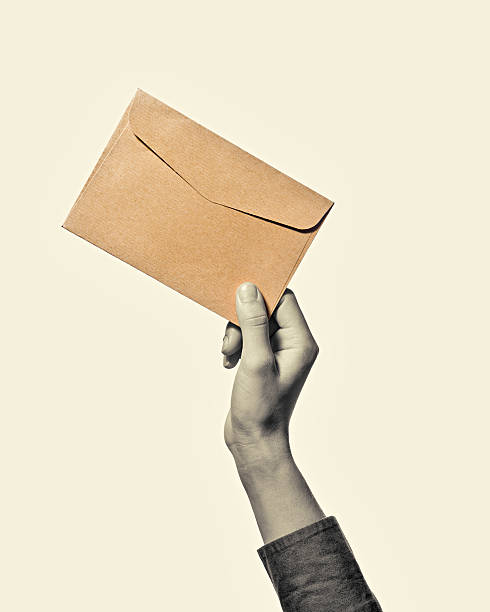 Hand with envelope b/w Hand with envelope from kraft paper, isolated, toned, black and white received stamp stock pictures, royalty-free photos & images