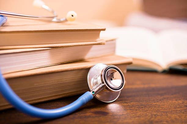 istock Close-up of doctor's stethoscope on desk with books.  Reading, studying. 579437470