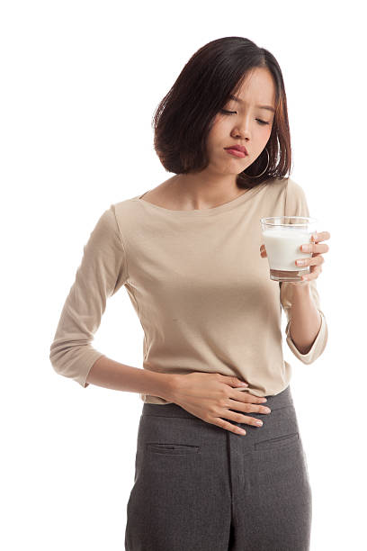 femme asiatique, boire un verre de lait a maux d'estomac - got milk photos et images de collection