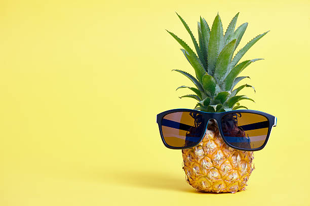 istock Pineapple with sunglasses on yellow background 579442164