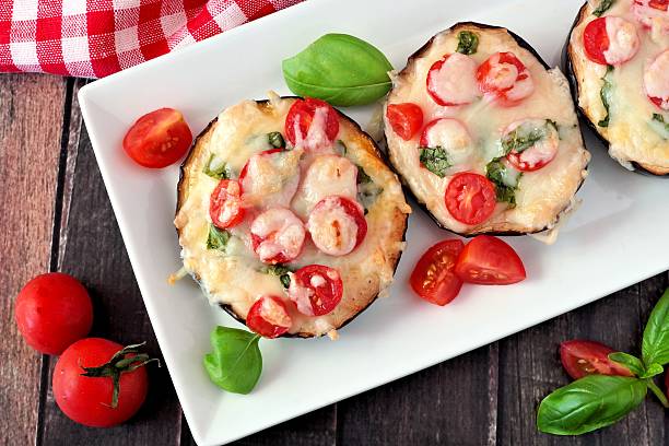 istock Eggplant pizzas with mozzarella, tomatoes and basil on white plate 579443812