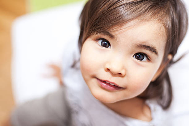 Smiling small girl looking at camera, top view