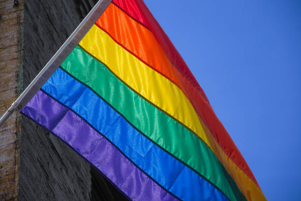 istock Gay pride flag in a building over a blue sky 579730984