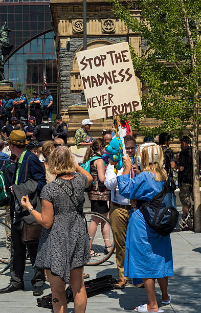 Trump madness Cleveland, United States - July 20, 2016: A protester dressed as a psych-ward patient holds up an anti-Trump sign on Public Square during the Republican National Convention. rnc stock pictures, royalty-free photos & images
