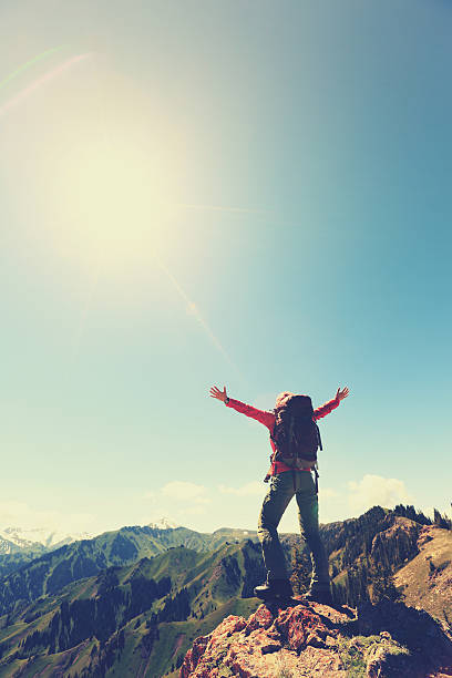 istock cheering successful woman backpacker open arms on mountain peak 579736664