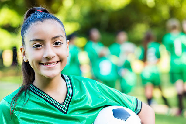 istock Pretty soccer player holding the ball with her team 579736704