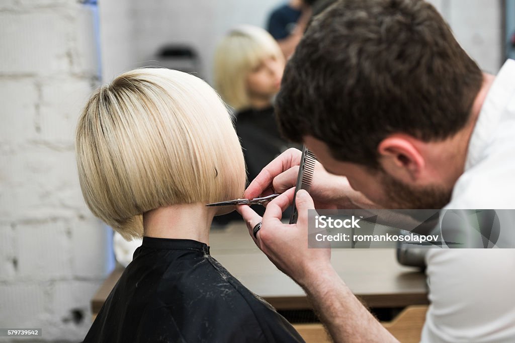 Hairdresser cutting client's hair in salon with electric razor Hairdresser cutting client's hair in salon with electric razor closeup Hairdresser Stock Photo