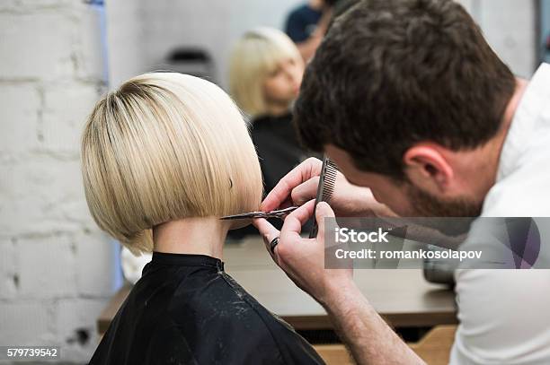 Hairdresser Cutting Clients Hair In Salon With Electric Razor Stock Photo - Download Image Now