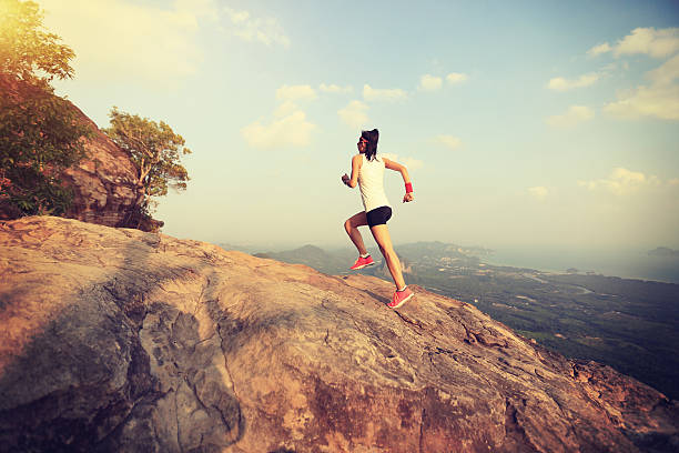 istock young asian woman runner running on mountain peak 579741978