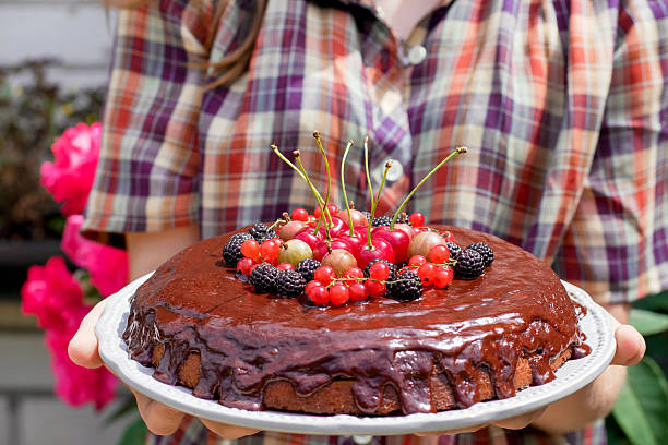 istock Hands holding chocolate cake decorated with berries. 579742724