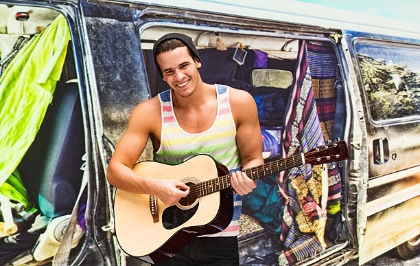 Smiling backpacker playing guitar outdoorshttp://www.twodozendesign.info/i/1.png
