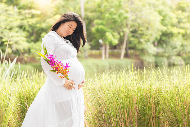 mulher grávida carrega a barriga no jardim - rape flower - fotografias e filmes do acervo