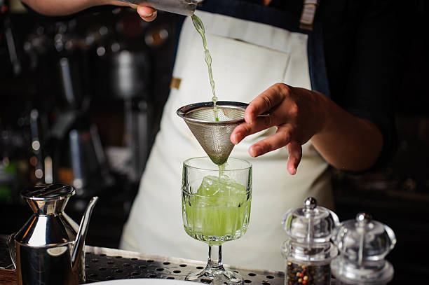 istock Bartender pouring fresh cocktail in fancy glass 579747382