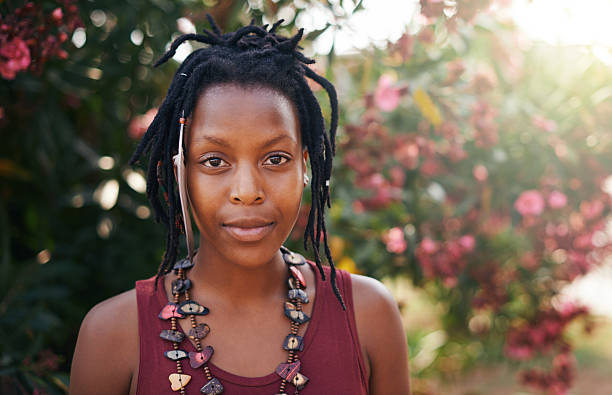Portrait of Black smiling woman holding white roses