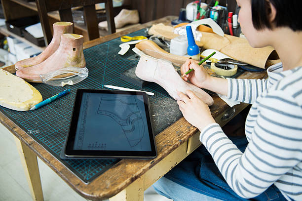 istock Young female entrepreneur in her shoe making studio 579750436