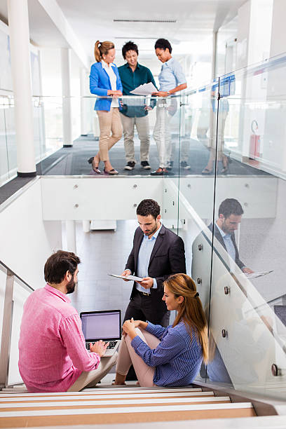istock Group of business people working in office building lobby. 579751644