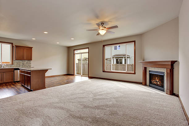 istock Large empty living room interior with carpet floor and fireplace. 579752224