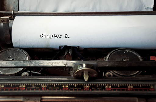 close up image of typewriter with paper sheet and the phrase: Chapter 2. copy space for your text. retro filtered