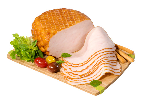Thinly sliced chicken breast on a cutting board with decoration,isolated on white with clipping path.