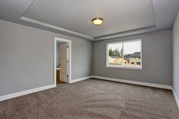 istock Grey empty basement room with carpet floor and window. 579756296