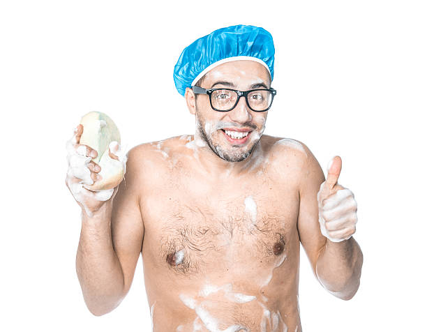 Man bathing in a bathroom Young attractive man cheerfully washes her body in bathroom, isolated on white background, studio shot. shower men falling water soap sud stock pictures, royalty-free photos & images