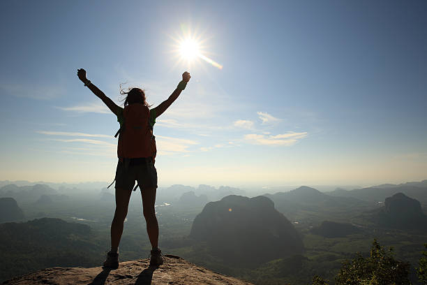 istock cheering woman hiker at sunrise mountain peak 579757634
