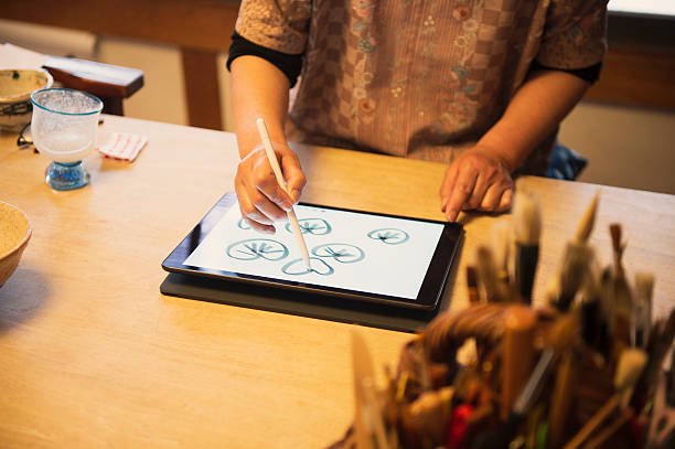 istock Lacquer craftsmen thinking the design in the digital tablet 579757902
