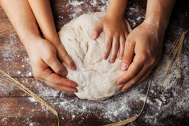 vater und kind bereiten teig mit mehl und weizenohren zu - bread kneading making human hand stock-fotos und bilder