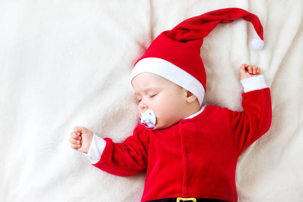 bambino che dorme in costume da babbo natale - baby santa claus christmas sleeping foto e immagini stock