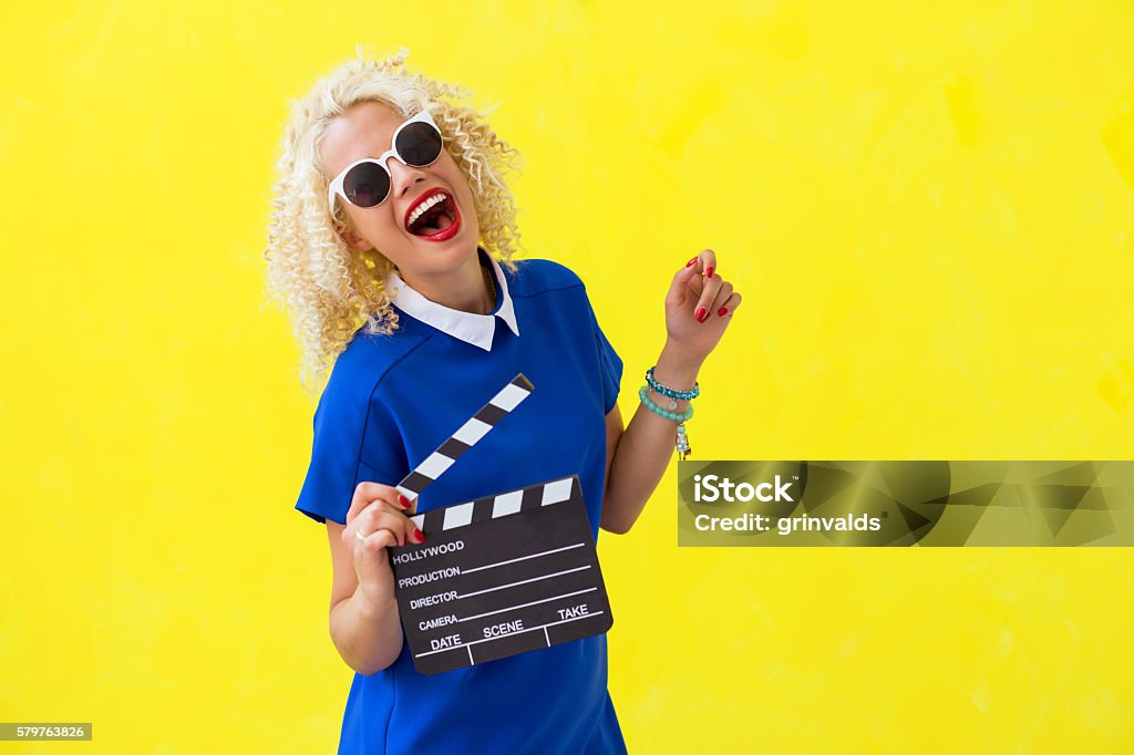 Woman holding a movie directors scene card Woman holding a movie directors scene card  Acting - Performance Stock Photo