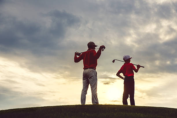 homme avec son fils golfeurs - golf golf swing men professional sport photos et images de collection