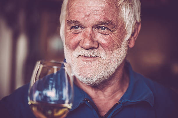 istock Senior Man with Beard Drinking Glass of White Wine 579768106