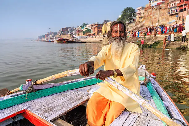 Photo of Sadhu rowing boat on the holy Ganges River in Varanasi