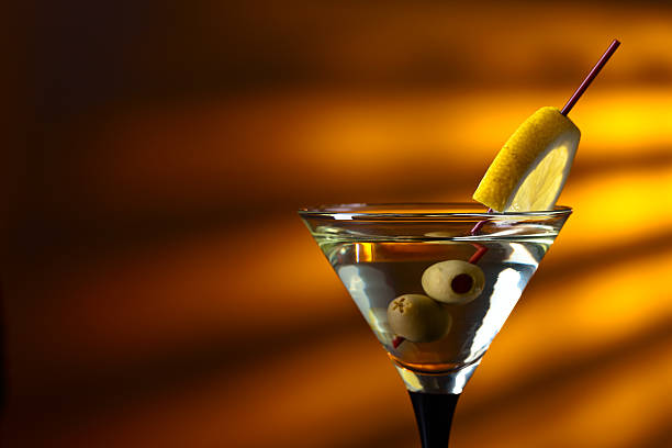 Glass of martini with lemon and green olives