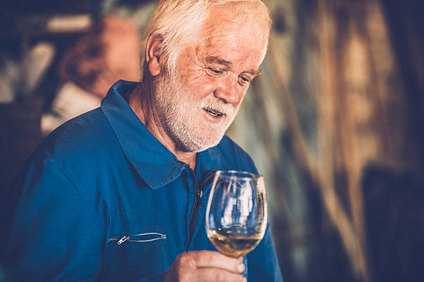 istock Senior Man with Beard Drinking Glass of White Wine 579770462