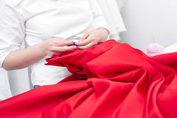 портной шьет красное платье - sewing women tailor teenage girls стоковые фото и изображения