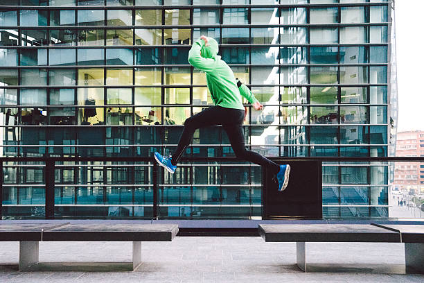 Man Running And Jumping, Outdoors Sport Training Mature man running and jumping during sport training outdoors, cityscape on background. free running stock pictures, royalty-free photos & images